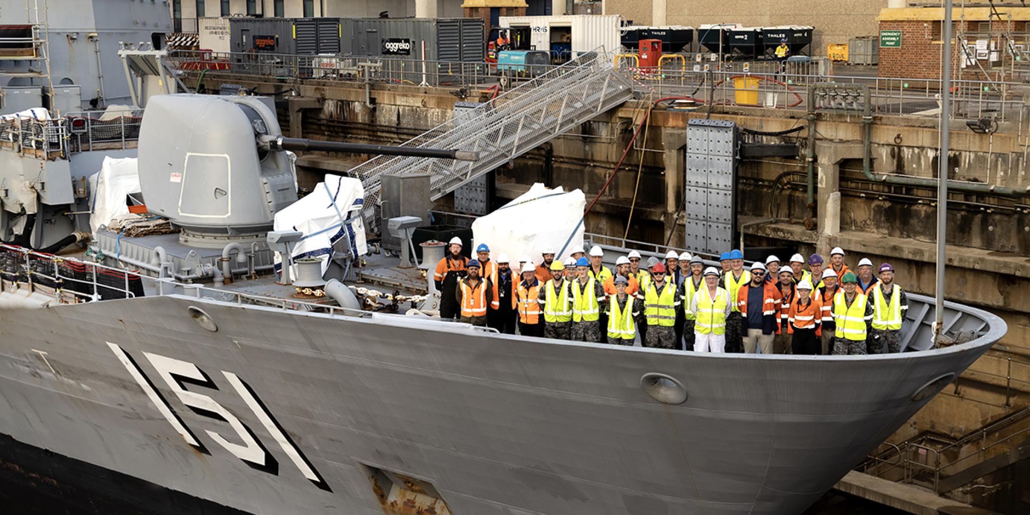 Large Royal Australian Navy ship, with shipbuilders on the prow Large Royal Australian Navy ship, with shipbuilders on the prow
