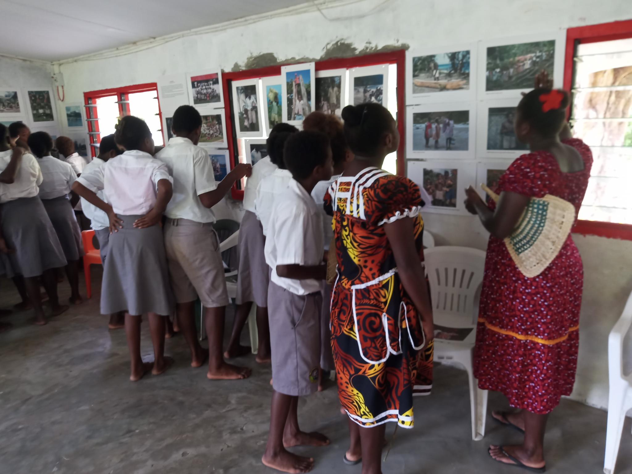 Teachers and secondary students at Wintua inspect the historic photographs. Photographer, Paul Mitchell